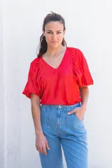 Blusa roja con escote en pico y mangas cortas abullonadas.