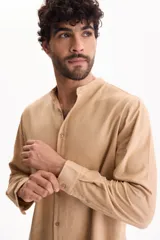 Camisa de manga larga color beige con cuello mao y cierre frontal con botones.