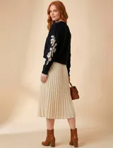 Suéter de punto negro con cuello redondo y bordados florales en hilo dorado en ambas mangas.