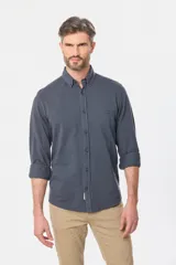 Camisa de manga larga color verde oscuro, con cuello abotonado y logo bordado en el pecho.