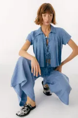 Zuecos de cuero color bordó con punta cuadrada, detalle de abertura en el empeine y aplique metálico dorado.