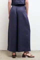 Pantalón blanco de lino, de corte palazzo, tiro alto y pierna ancha.