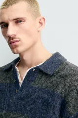 Polo de punto con textura, diseño de rayas horizontales en tonos gris y azul, cuello solapa con cierre frontal de botones y mangas largas con terminaciones en rib.