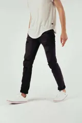 Pantalón de jean negro con diseño de roturas y efecto desgastado, corte ajustado y ruedo doblado.