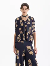 Remera de punto morley, color azul marino, con estampado de frutos en tono beige. Presenta escote en V y mangas cortas a la altura del codo, con un calce amplio.