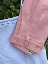 Pantalón de tusor color rosa con corte recto, bolsillos laterales y botón en el tobillo.