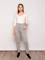 Pantalón tipo babucha de corte deportivo, color beige, con cintura elástica ajustable mediante cordón, puños en los tobillos y bolsillos frontales.