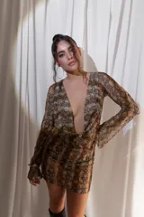 Vestido corto confeccionado en tul y lycra con estampado animal print de serpiente, escote en V pronunciado y mangas largas con diseño acampanado.
