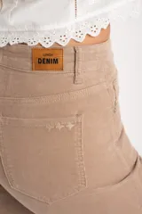 Pantalón de pana color beige, tiro medio, corte recto y largo al tobillo.