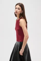 Musculosa de corte al cuerpo con cuello redondo y diseño sin mangas, confeccionada en tejido liso.