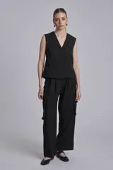 Chaleco negro con escote en V y cierre frontal con botones.