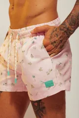 Short de baño rosado con estampado tropical de palmeras y vehículos, con cintura elástica con cordón ajustable.