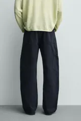 Pantalón cargo straight fit de algodón color negro con efecto lavado, bolsillos laterales en las piernas y cierre frontal con cremallera y botón.