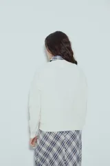 Sweater de punto color negro, con cuello redondo y diseño texturizado con ondas en relieve. Presenta mangas largas y un calce cómodo y holgado.