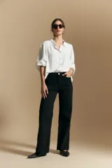 Camisa de manga larga color celeste, con cuello clásico, cierre frontal con botones y puños elastizados con volados. Presenta un diseño fluido con detalle de vainilla en la espalda.