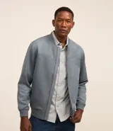 Chaqueta bomber azul marino lisa, con cierre frontal, cuello redondo y bolsillos laterales.