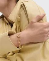 Dije colgante dorado con forma de palo de golf y pelota con incrustaciones de cristal.