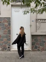 Pantalón de lanilla color negro, de corte recto y tiro alto, con diseño holgado y fluido.