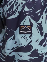 Campera técnica de esquí impermeable y cortaviento, con estampado abstracto en tonos azul marino y celeste. Cuenta con capucha ajustable, cierre frontal con tapeta, bolsillos con cierre, ventilación bajo los brazos y ajustes en los puños para protección contra la nieve.