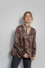 Camisa de seda con estampado floral en tonos bordó, marrón y negro. Presenta un corte amplio, escote en V con cierre frontal de botones, mangas largas abullonadas y frunces en hombros y espalda.