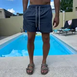 Short de baño negro con cintura elástica y cordón ajustable bicolor. Presenta un parche circular con logo en la parte inferior de la pierna.