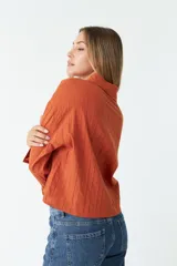 Camisa de manga larga color ladrillo con rayas verticales en relieve.