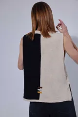 Chaleco de tejido de punto con diseño de bloques de color en tonos tierra, incluyendo marrón, verde oliva y beige. Presenta un panel central con textura tejida y cuello redondo.