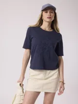 Remera blanca de algodón con bordado floral en el frente.