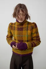 Jersey de punto con cuello perkins y manga larga, diseño a cuadros en tonos mostaza y marrón con detalles de costuras en color amarillo neón.