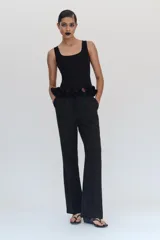 Pantalón de tiro bajo negro, corte flare con bajo evasé, bolsillos delanteros y cierre frontal con cremallera y botones.