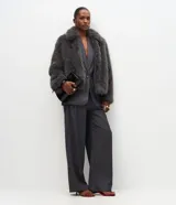 Pantalón de sastrería modelo wide leg color gris oscuro, con pliegues frontales, cintura estructurada con presillas y bolsillos laterales funcionales.