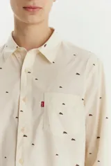 Camisa de manga larga color crema con estampado de montañas en marrón. Tiene un bolsillo en el pecho con el logo de la marca.