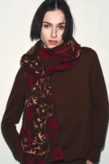 Pañuelo rectangular de gran tamaño con estampado floral en tonos bordó, marrón y beige, con bordes deshilachados.