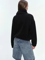 Campera de tela fleece doble, color negro, con cierre frontal completo, cuello alto y bolsillos laterales. Presenta puños y bajo elastizados para un ajuste cómodo.