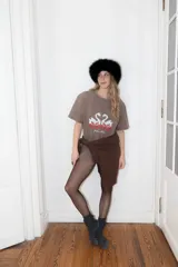 Remera de algodón color marrón con efecto lavado, de corte holgado y manga corta. Presenta una estampa frontal con dos cisnes enfrentados en color blanco y rojo con detalles geométricos.