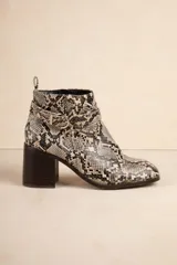 Botas de caña baja con estampado de piel de serpiente en tonos grises y negros, con hebilla metálica y cierre lateral. El taco es de 8cm de alto.