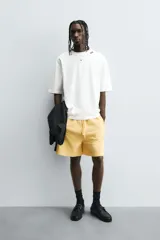 Camiseta de algodón blanca con corte relajado y cuello redondo. Presenta un pequeño bordado en negro con la palabra "BULB" en la parte superior del pecho.