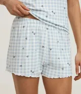 Conjunto de pijama short doll de punto, estampado de cuadros vichy celestes y blancos con mini corazones negros. Incluye un top de breteles finos con escote en V y un short con cintura elástica.