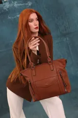 Cartera tipo tote de diseño estructurado en símil cuero, con doble asa rígida y correa regulable. Presenta múltiples bolsillos frontales con cierre y solapa, ofreciendo un estilo versátil y espacioso.