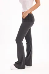 Pantalón calza gris melange de corte flare, tiro alto con cintura rebatible ancha y ajuste entallado en las piernas que se ensancha hacia los tobillos.
