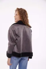 Campera gris oscuro con cuello alto con solapa y cierre con hebillas.