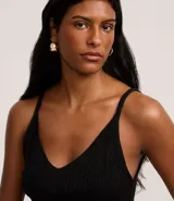 Musculosa de punto canelado en color negro con hilo metalizado, escote en V y breteles finos.