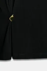 Camiseta de algodón compacto color negro, con cuello redondo, manga corta y detalle de aplique metálico en el frente que genera un ligero fruncido lateral.