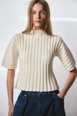 Top de punto acanalado color negro, con cuello redondo y mangas cortas abullonadas.