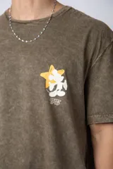 Remera de algodón con efecto acid wash en color gris oscuro. Presenta un diseño estampado en el pecho con una estrella amarilla y un personaje animado, y un corte semi-oversize.