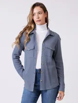 Sobrecamisa de tela texturada tipo waffle, color gris, con cuello camisero, cierre frontal con botones y bolsillos frontales con solapa.