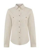 Blusa de manga larga color beige, confeccionada en mezcla de algodón orgánico, nylon y elastano, con tecnología de protección solar UPF +50. Cuenta con cuello camisero, cierre frontal con botones y dos bolsillos delanteros en el pecho con solapa y botón.