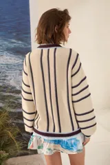Cardigan de punto a rayas verticales en tonos marrón chocolate, blanco y amarillo, con escote en V, mangas largas y cierre frontal con botones.