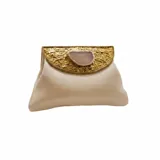Cartera tipo sobre de yute de algodón color crudo, con solapa y aplique metálico dorado texturizado que incluye una piedra de ágata al centro. Cuenta con correa de cadena para llevar al hombro.