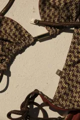 Top de bikini triangular reversible con estampado geométrico en tonos fucsia y gris. Se ata al cuello y a la espalda con tiras finas.